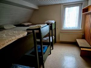 a room with three bunk beds and a window at Vater Bender Heim in Schotten