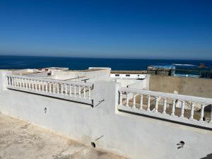 a white building with a balcony with the ocean in the background at Dar Yessine Boutique Hôtel in Sousse