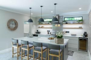 a kitchen with a large island with bar stools at Saffron House in Hermanus