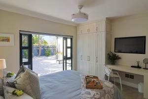 a bedroom with a bed and a sliding glass door at Saffron House in Hermanus