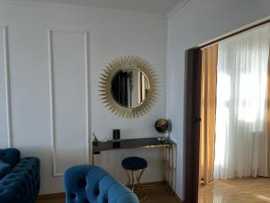 a living room with a mirror and a blue chair at APARTMANI JERKOVIĆ - DUNAV 2 in Vukovar