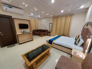 a hotel room with a bed and a flat screen tv at Hotel Vrinda in Maihar