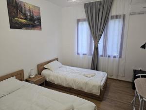 sypialnia z 2 łóżkami i oknem w obiekcie Casa Dragoste w mieście Someşu Cald