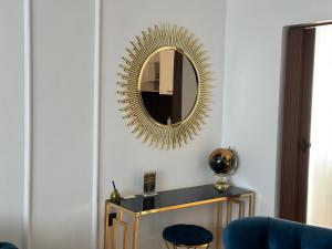 a mirror on a wall above a table with a blue chair at APARTMANI JERKOVIĆ - DUNAV 2 in Vukovar