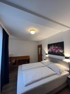 a bedroom with a large white bed with a painting on the wall at Hotel 9-enhof in Wuppertal
