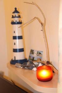 Una mesa con una vela y un faro encima. en 4 Sterne Apartment Seeschwalbe mit Sauna und Terrasse, en Lobbe