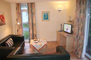 una sala de estar con un sofá y una mesa en 4 Sterne Apartment Seeschwalbe mit Sauna und Terrasse, en Lobbe