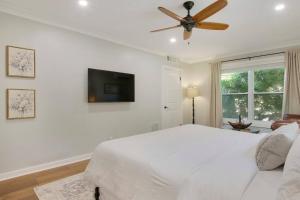 西棕榈滩Cozy Studio Downtown WPB -Unit C的一间带床和吊扇的白色卧室