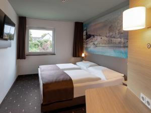 Habitación de hotel con cama y ventana en B&B Hotel Koblenz en Koblenz