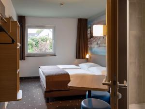 une chambre d'hôtel avec un lit et une fenêtre dans l'établissement B&B Hotel Koblenz, à Coblence