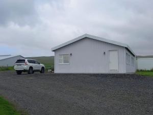 un camión blanco estacionado frente a un edificio blanco en Countryhouse with great view on Eyjafjallajökull, en Hvolsvöllur