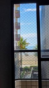 une fenêtre donnant sur un bâtiment dans l'établissement Apartamento Praia Grande Aviação 50m praia, à Praia Grande