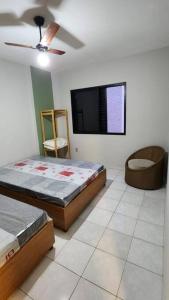 - une chambre avec 2 lits et une télévision à écran plat dans l'établissement Apartamento Praia Grande Aviação 50m praia, à Praia Grande