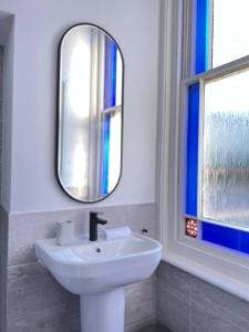a bathroom with a sink and a mirror at Pass the Keys Lovely 1-bedroom flat in St Leonards on Sea in Hollington