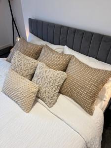 a bed with four pillows on top of it at Pass the Keys Lovely 1-bedroom flat in St Leonards on Sea in Hollington