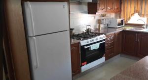 a kitchen with a white refrigerator and a stove at Shahed Apartment in Amman