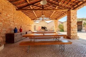 un grupo de mesas en una habitación con una pared de ladrillo en Quinta da Cortiça - Casa da Torre, en Alvaiázere