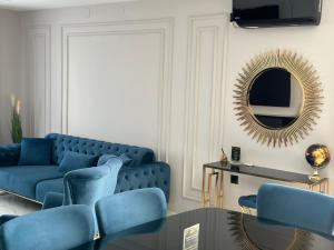 sala de estar con sofá azul y espejo en APARTMANI JERKOVIĆ - DUNAV 1 - Premium en Vukovar