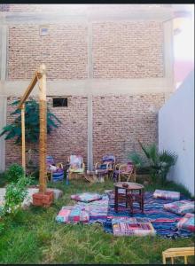 a backyard with a table and chairs and a brick wall at Princess carine in Luxor