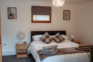 a bedroom with a bed and a window at Stunning Lodge with Hot Tub on Private Lake in Harrogate