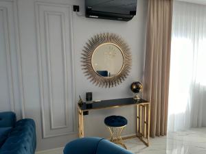 a living room with a mirror and a blue couch at APARTMANI JERKOVIĆ - DUNAV 1 - Premium in Vukovar