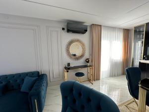 ein Wohnzimmer mit einem blauen Sofa und einem Spiegel in der Unterkunft APARTMANI JERKOVIĆ - DUNAV 1 - Premium in Vukovar