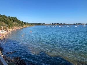 a group of people swimming in the water on a beach at Maison au calme proche des plages du Golfe du Morbihan in Baden