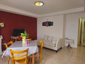 sala de estar con mesa y sofá en Hermoso Duplex con vista al Estuario. en Río Gallegos