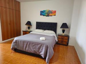 1 dormitorio con 1 cama grande y 2 mesitas de noche en Hermoso Duplex con vista al Estuario. en Río Gallegos