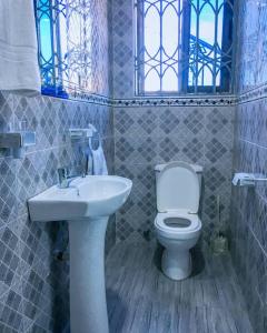 ein Badezimmer mit einem weißen WC und einem Waschbecken in der Unterkunft Pro CeDi Ventures Self-catering in Kasoa