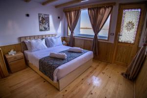 a bedroom with a bed with two pillows on it at Dahabiya Akhnaton Every Monday from Esna to Aswan for 4 Nights in Luxor