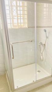 eine Dusche mit Glastür im Bad in der Unterkunft Favoured Apartment in Kwabenyan
