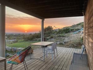 a table and chairs on a deck with the sunset at Belle villa en Provence in Lançon-Provence