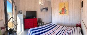 um quarto com uma cama com uma cómoda vermelha e uma televisão em Belle villa en Provence em Lançon-Provence