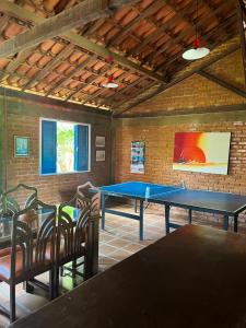 Cette chambre comprend une table de ping-pong et des chaises. dans l'établissement HOSTEL DAS ESTRELAS, à Areal