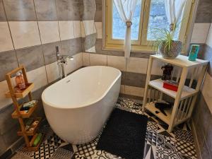 a bathroom with a large white tub in a room at Honey Moon in Saint-Bonnet-en-Champsaur