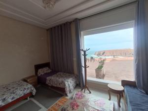 a bedroom with a window with a view of the desert at Goldenbeachhouse in Mirleft +16 photos