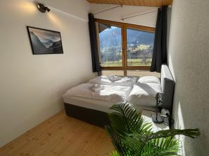 um quarto com uma cama e uma grande janela em homy Alpine Deluxe Chalet in St Anton im Montafon em St. Anton im Montafon