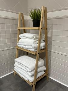 una pila de toallas en una estantería de madera en el baño en Mirador Templario, en Jerez de los Caballeros