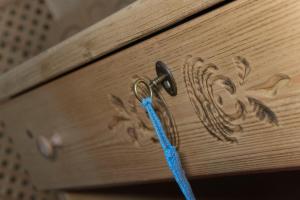 een stuk blauw touw bevestigd aan een houten lade bij Hotel B&B Monica in Arabba