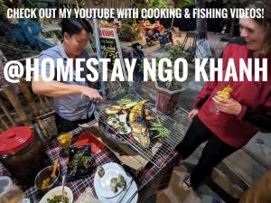 een groep mensen die rond een tafel met eten staan bij NGO KHANH Homestay in Tân Hiệp