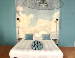 - une chambre avec un grand lit orné d'une fresque murale représentant les nuages dans l'établissement B&B Les chambres d'Aimé, à Carcassonne