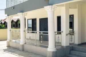 ein Gebäude mit weißen Säulen und einem Balkon in der Unterkunft Pro CeDi Ventures Self-catering in Kasoa