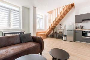 Una sala de estar con un sofá y una cocina. en Résidence Jaurès, en Marly