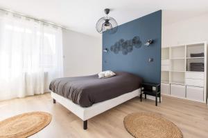 Un dormitorio con una cama y una pared azul. en Résidence Jaurès, en Marly