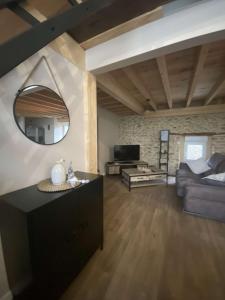 salon z kanapą i lustrem w obiekcie La Grange du Pradel w mieście Montredon-Labessonnié
