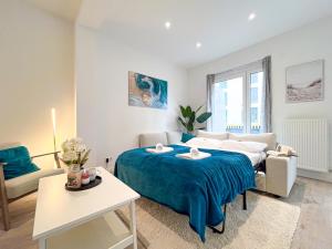 a bedroom with a blue bed and a couch at Rosenberg-Oase - Zentral, Stellplatz, 78m2, große Terasse, Business & Privat in Heilbronn