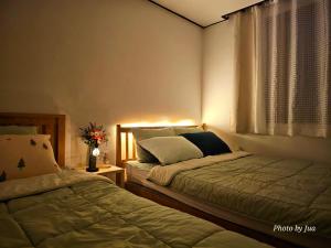 a bedroom with two beds and a window at Romantic sillim in Seoul