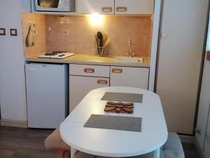 a small kitchen with a white table and a sink at Studio La Plagne Montalbert , 1 pièce, 3 personnes - FR-1-181-2544 in Aime-La Plagne