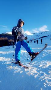 Un uomo sta sugli sci nella neve di Villa Green Park a Prizren